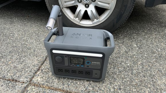 Anker portable power station sitting in front of a car wheel