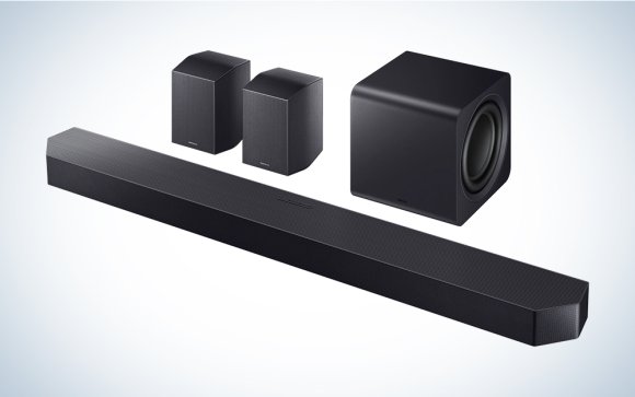 Black Samsung HW-990F wireless surround sound system, including soundbar subwoofer and satellites, on a grey gradient