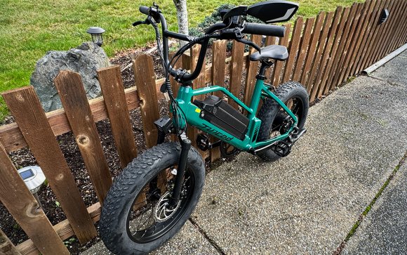 Juiced RipRacer fat tire electric bike leaning against a fence