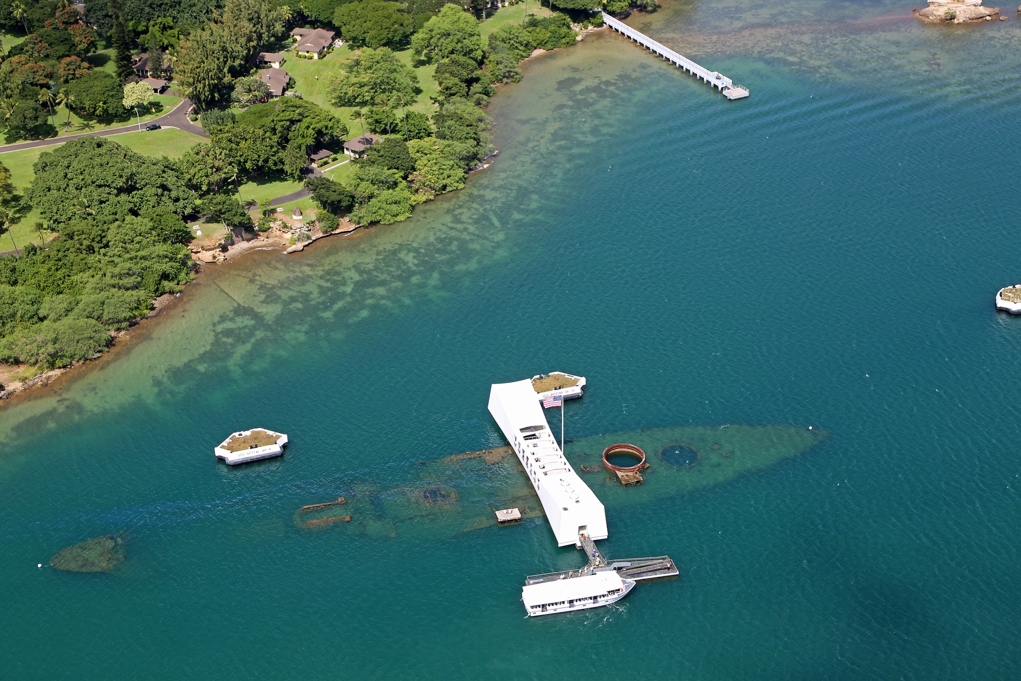 Pearl Harbor and USS Arizona Memorial on a blue-green lagoon in Oahu seen from the air