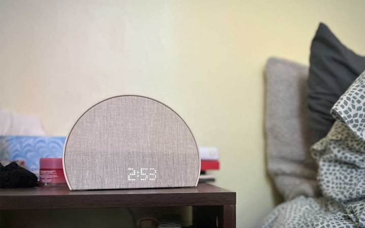  A grey Hatch Restore 2 sunrise alarm clock sitting on a bedside table. 