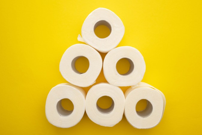 Toilet paper rolls on a yellow background to represent IBS causes