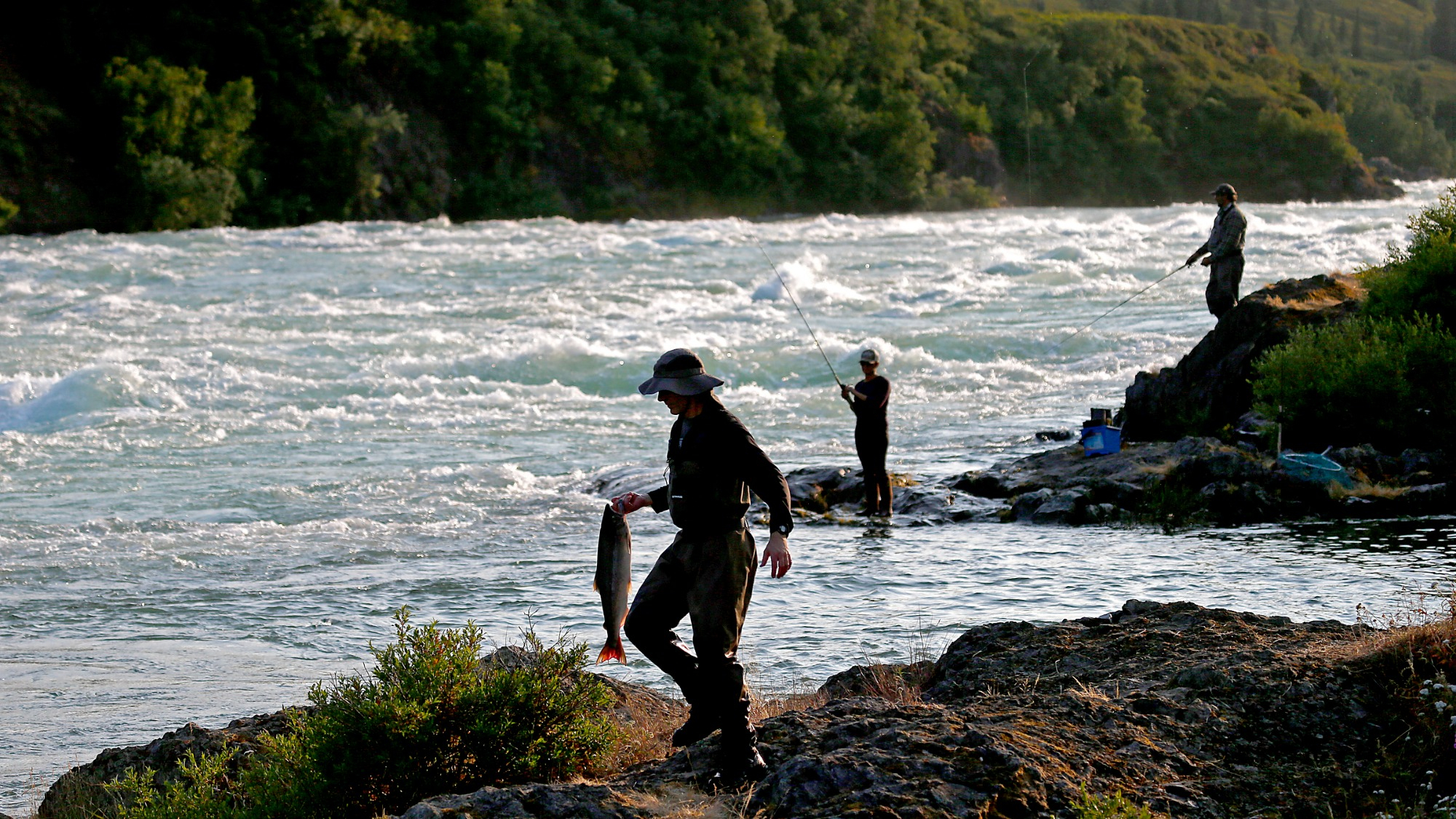 Three fishers fish for salmon in Alaska.