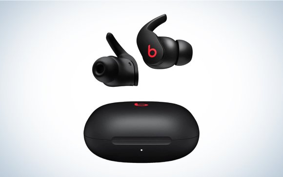 A pair of black Beats Fit Pro headphones on a blue and white background