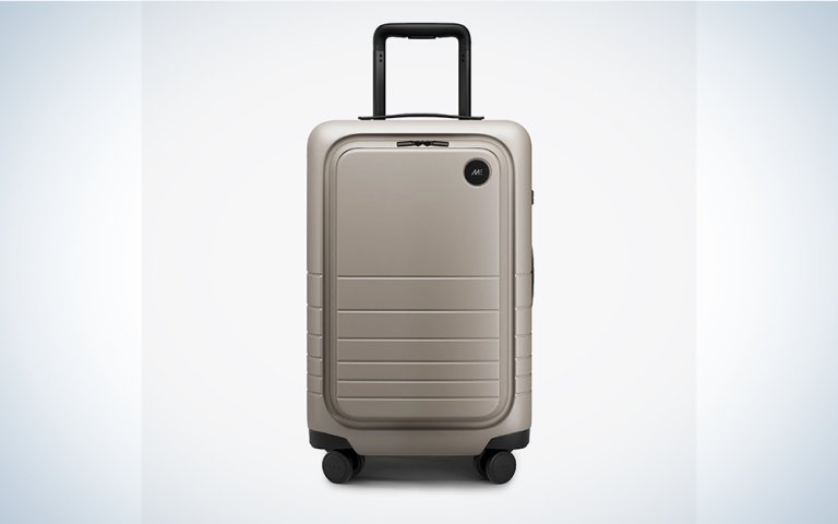A beige Monos carry-on on a blue and white background