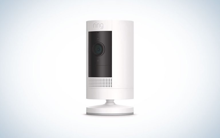 A white Ring wireless stick up camera on a plain background