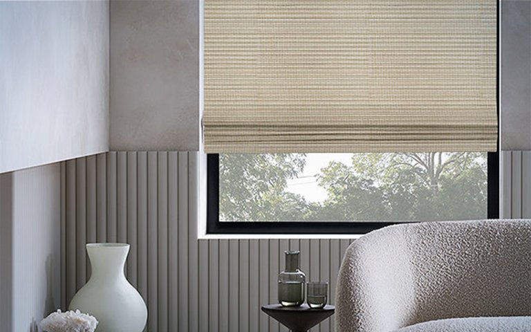 Shade Store Waterfall Woven Wood Shades behind neutral-toned furniture