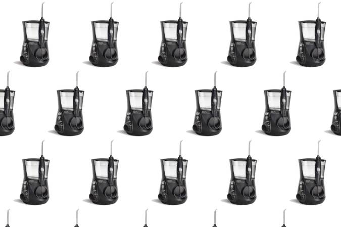 A black Waterpik Aquarius water flosser in a pattern on a plain background