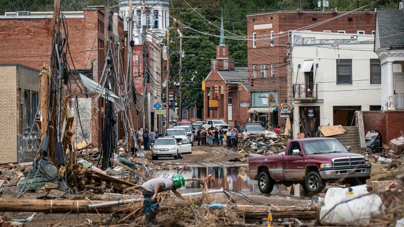 Workers, community members, and business owners clean up debris in the aftermath of Hurricane Helene in Marshall, North Carolina on Monday, Sept. 30, 2024.
