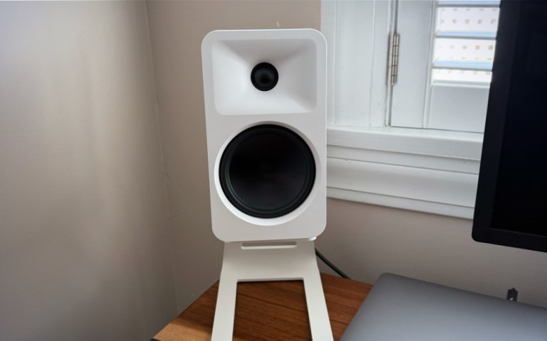 Kanto Ora4 speakers on a stand on top of a desk.