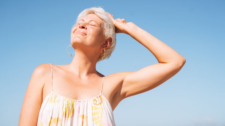 Portrait of happy young adult woman standing on the beach