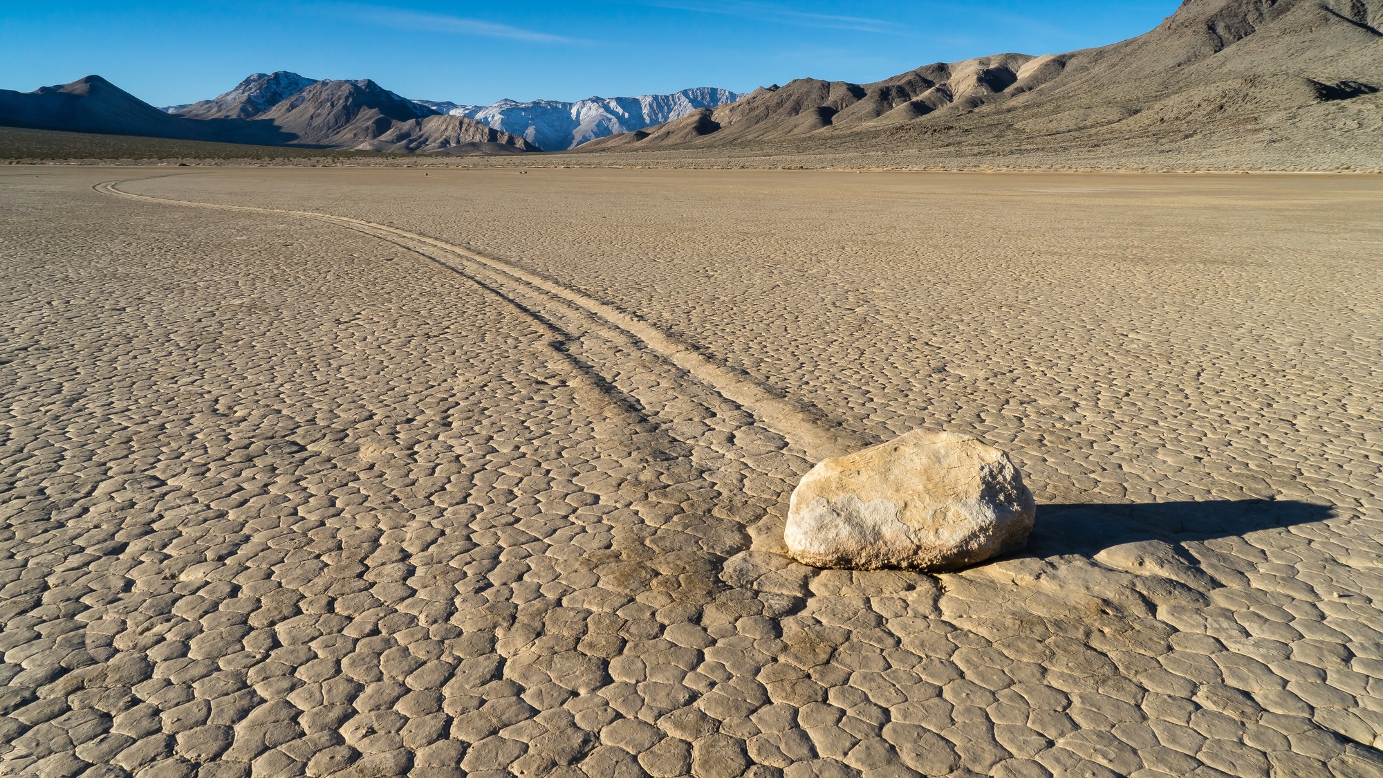 Sailing stone in Death Valley with movement trail behind hit