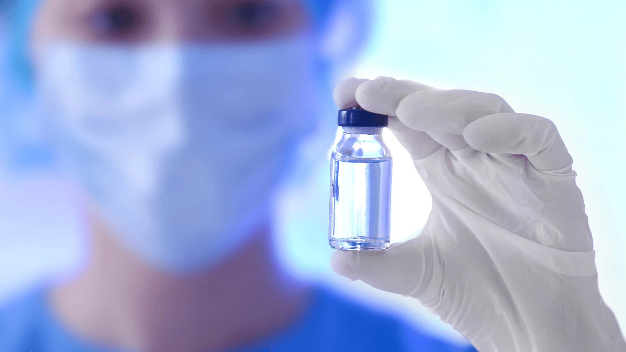 a doctor holds a vial of medicine