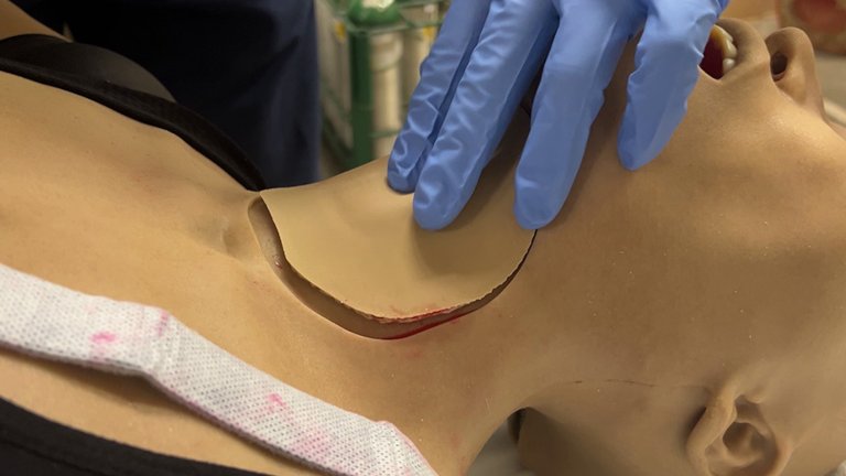 a mannequin with its neck skin being removed