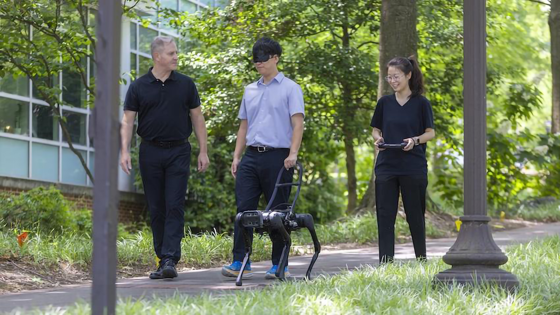 a robot dog walking with three humans