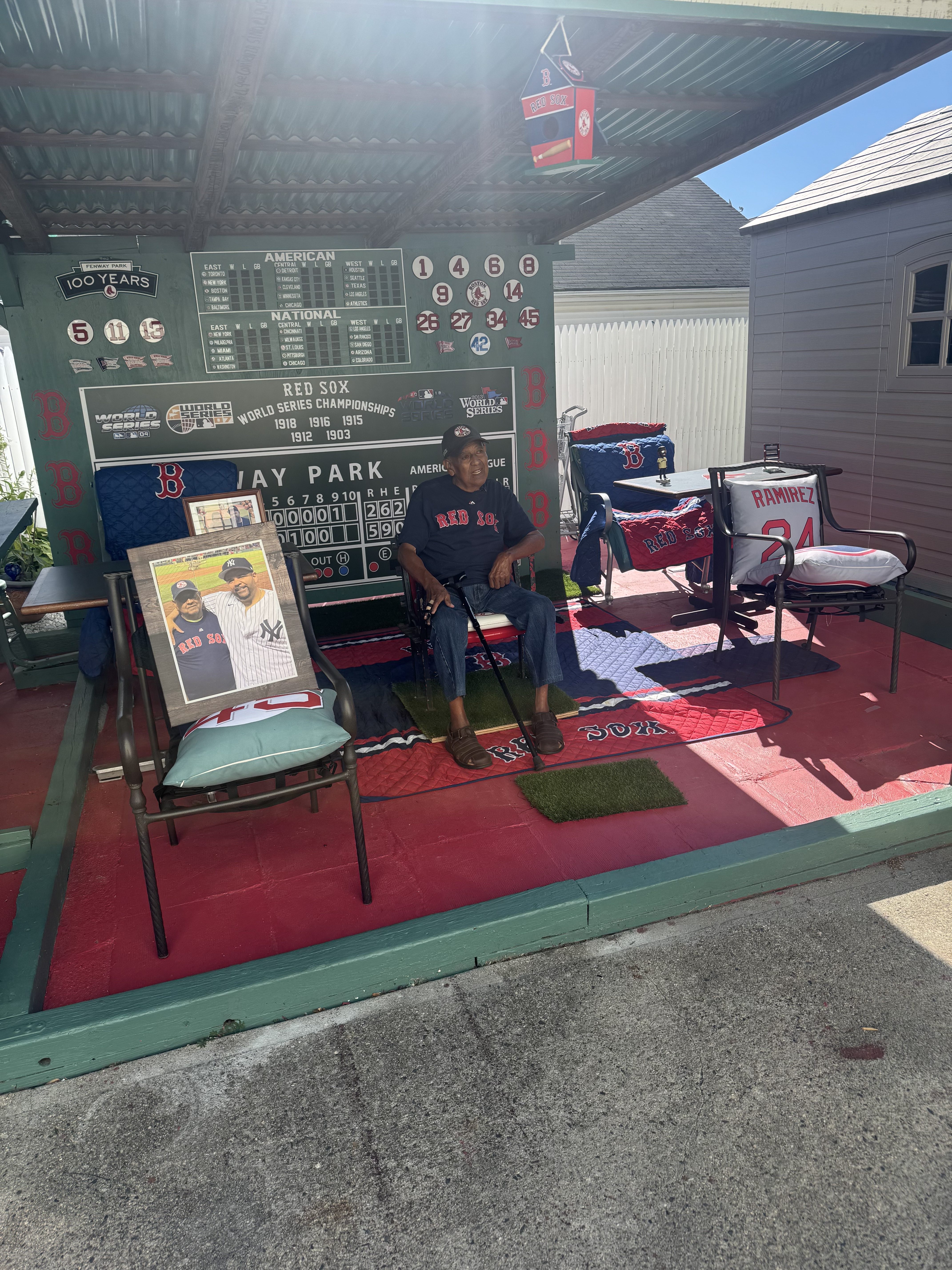 a man sits in a replica of fenway park built in his backyard