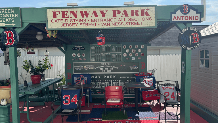 a backyard version of fenway park complete with a green monster, signs, and scoreboard