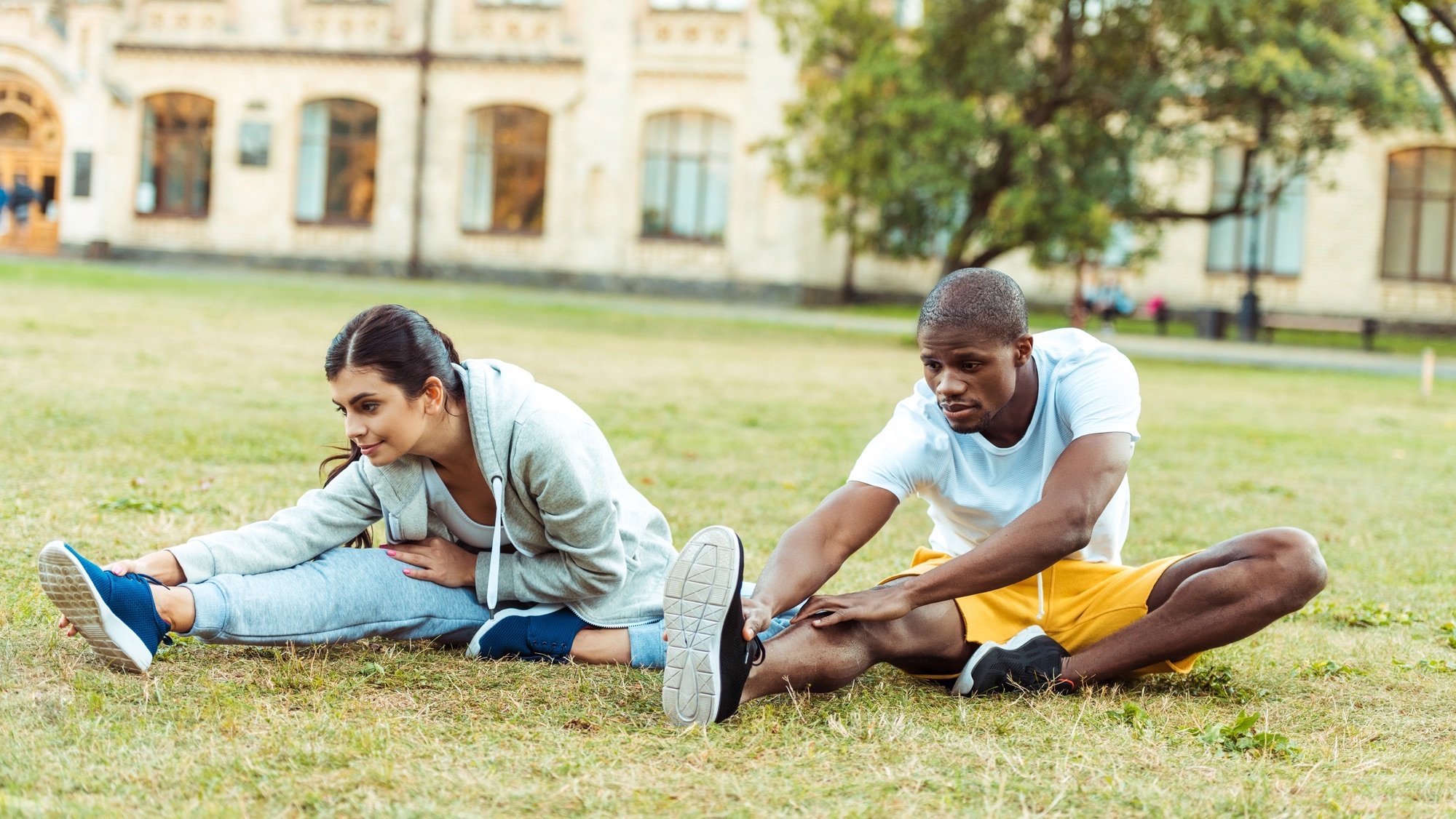 couple stretching on grass