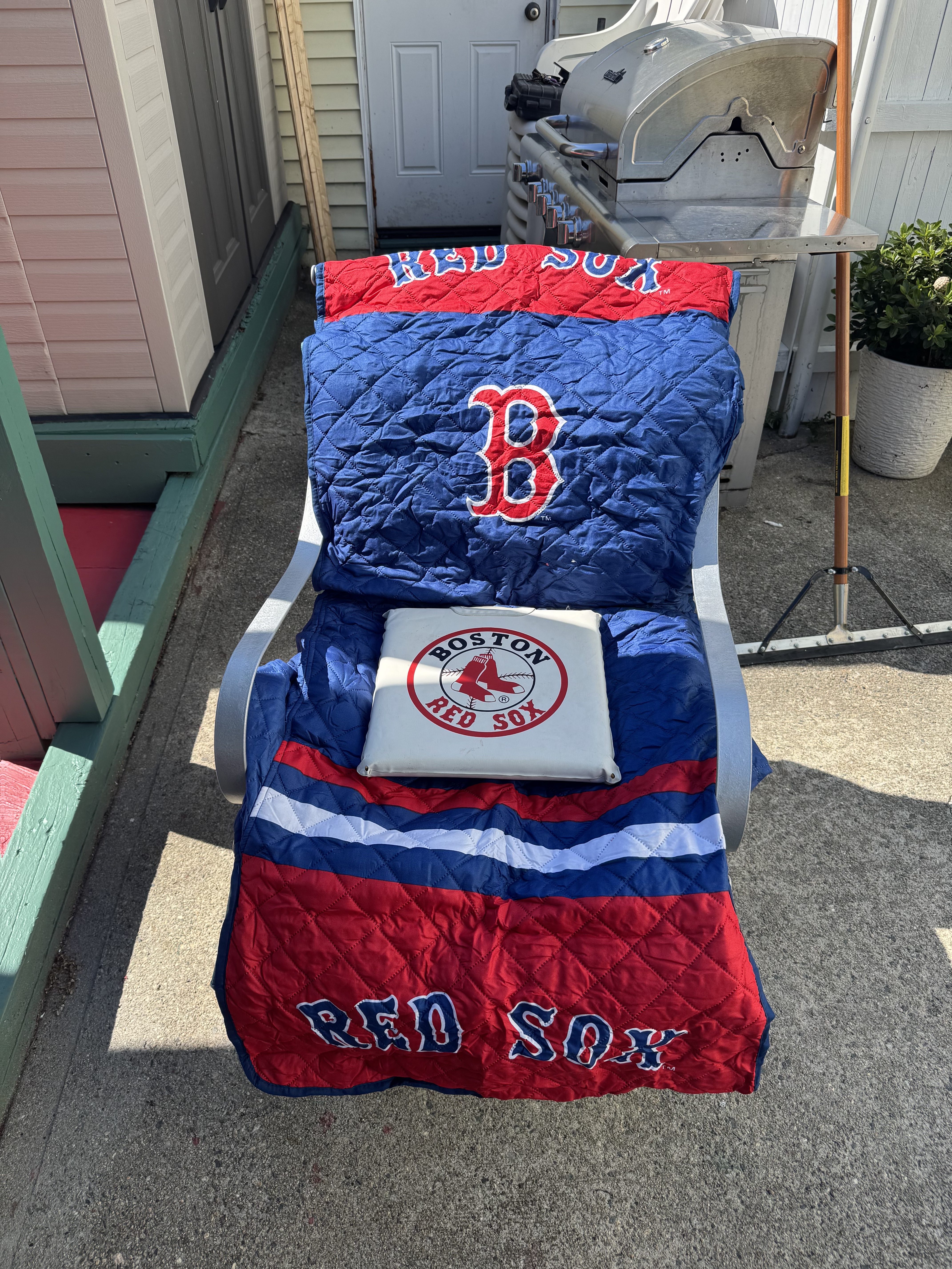 a chair with a Boston Red Sox blanked and seat cushion