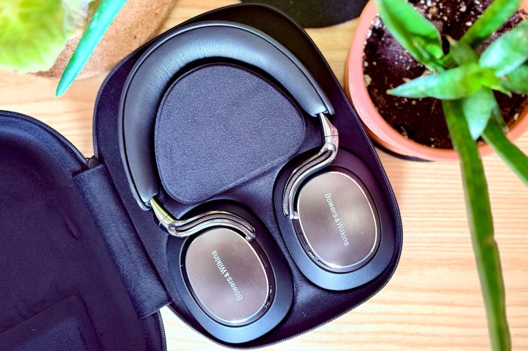 Onyx Black Bowers & Wilkins Px8 S2 headphones in their case amongst bright green plants.