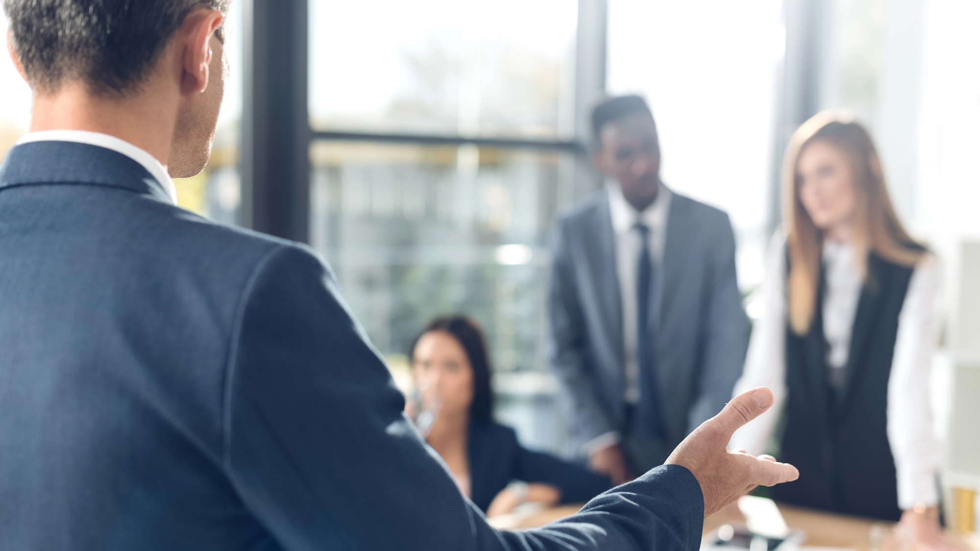Group of people speaking in conference room, out of focus image