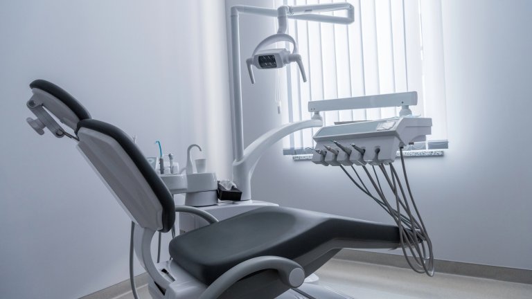 Empty dentist office showing tools and chair