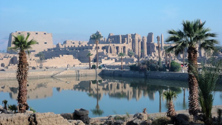 Karnak Temple next to the Nile River and palm trees