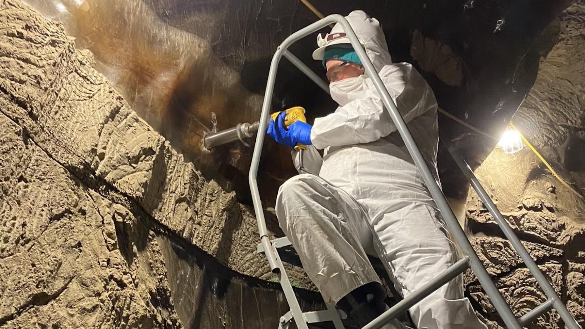 Scientist drilling permafrost core sample in Arctic tunnel