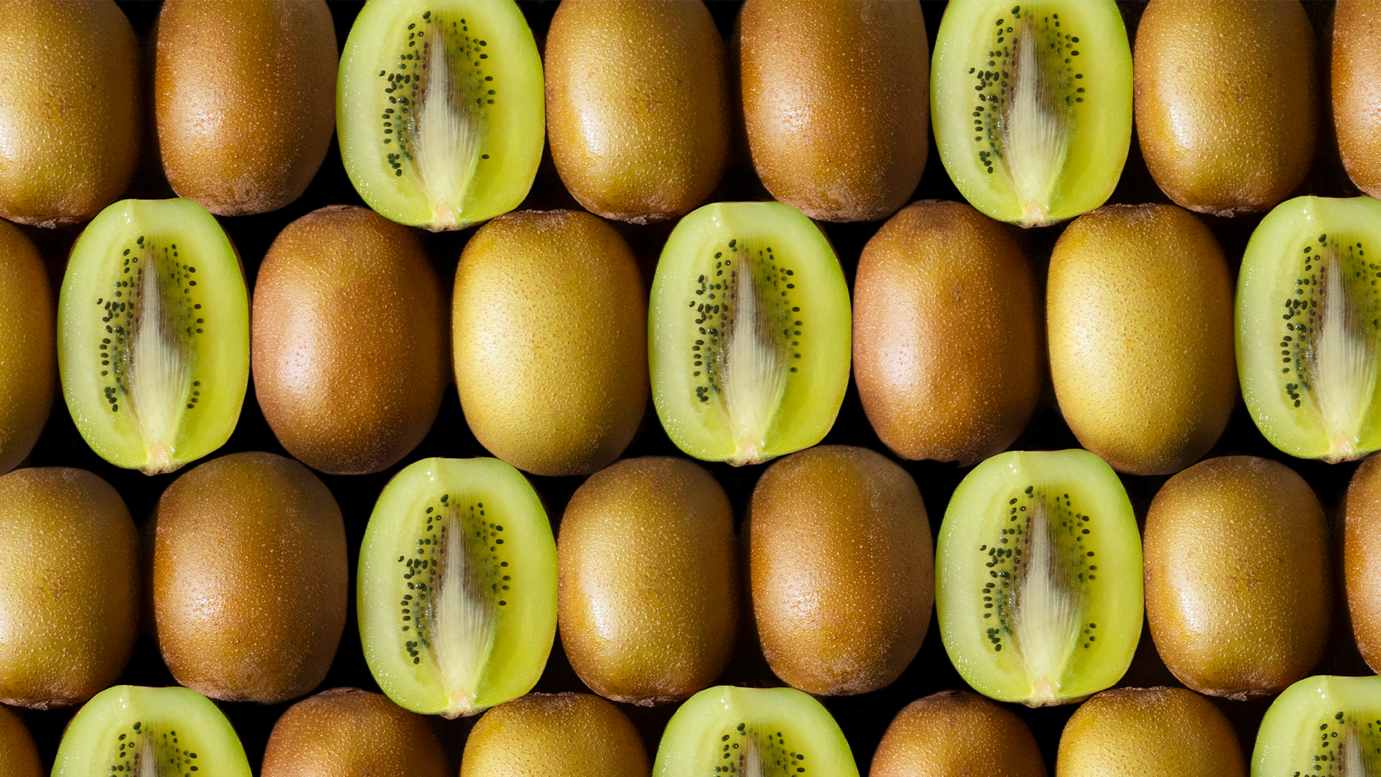 peeled and open kiwis. they have green fruit with brown skins