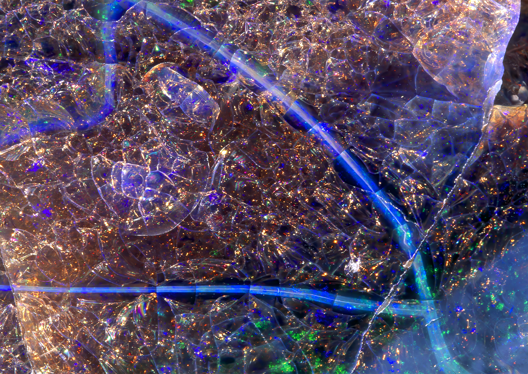 a close up of opal, with blue lights and dots of red and green