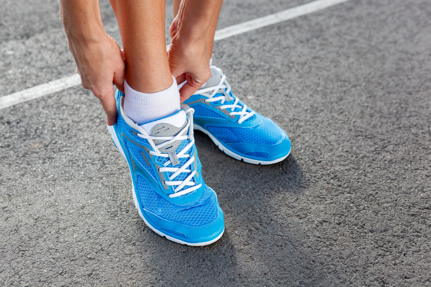 Closeup of Young Woman Tying Sports Shoe - concept image