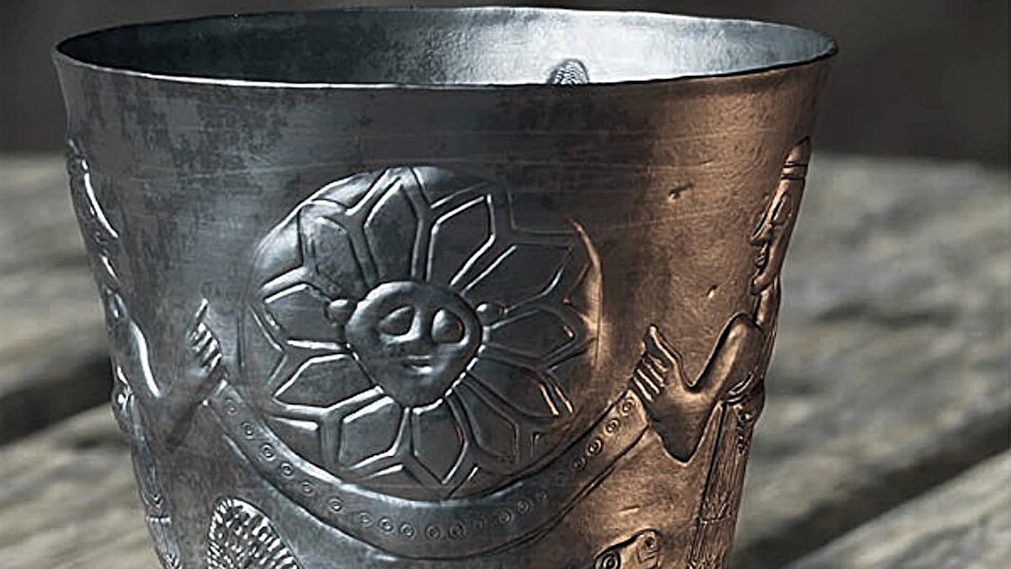 Close up of replica of silver goblet from Near East engraved with sun god