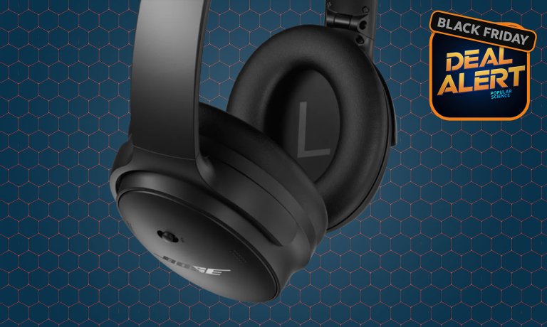 Close-up of the earcups of black Bose QuietComfort noise-canceling headphones on a dark blue Black Friday deal alert background