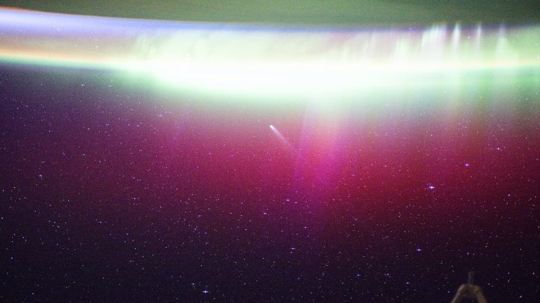 Comet passing above auroras on Earth