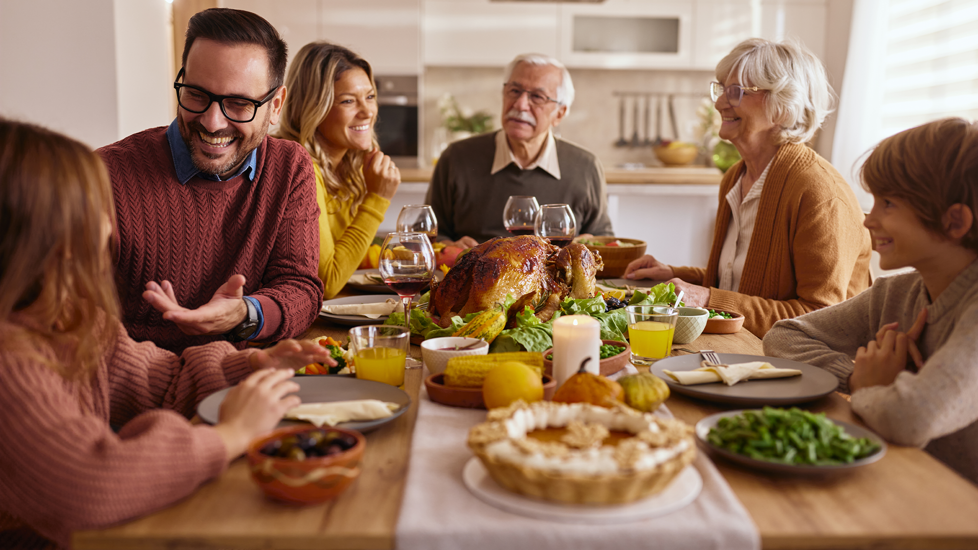 a family talking around the dinner tableSkynesher via Getty Images