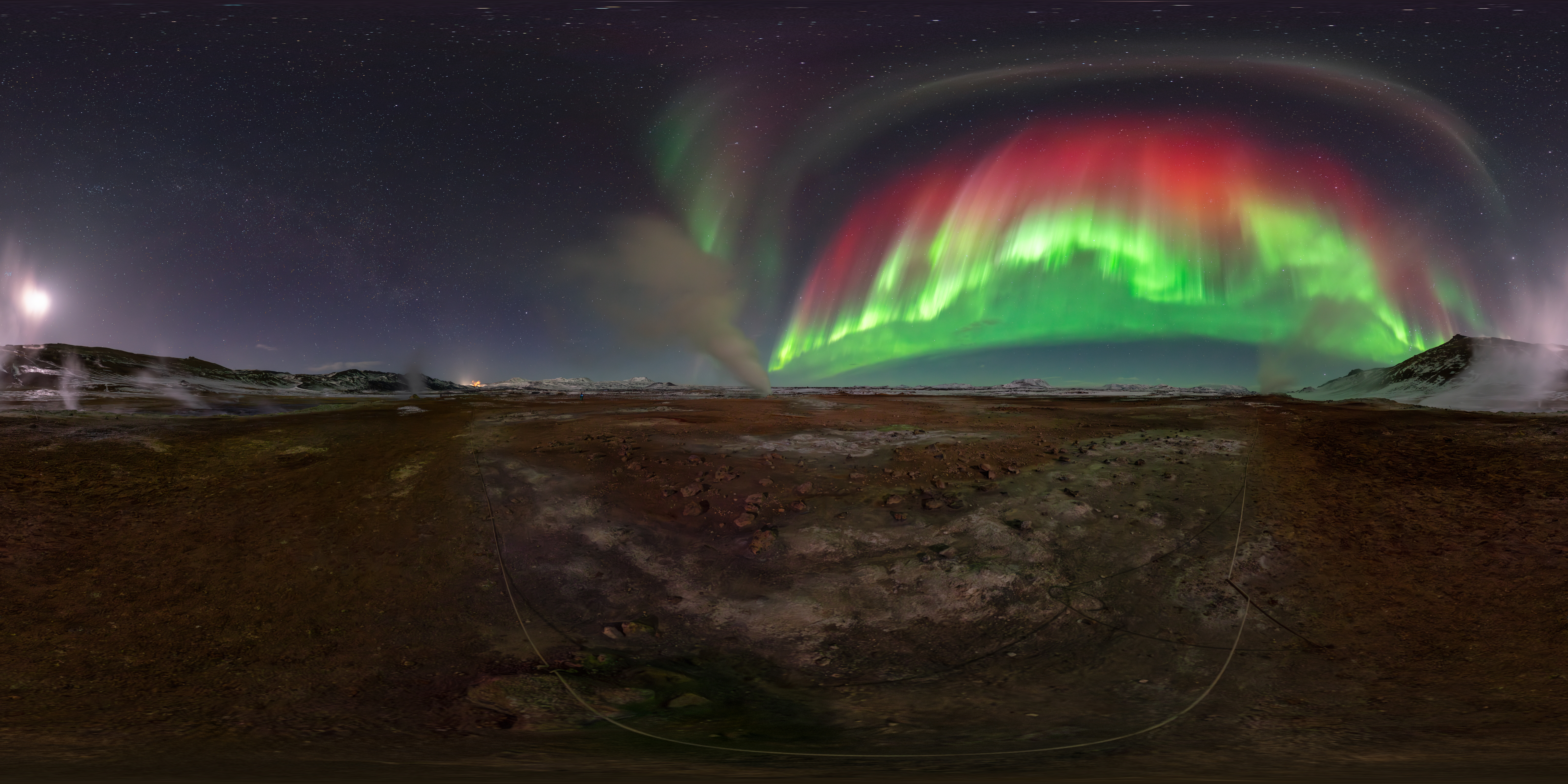 a green and red aurora over a geothermal field