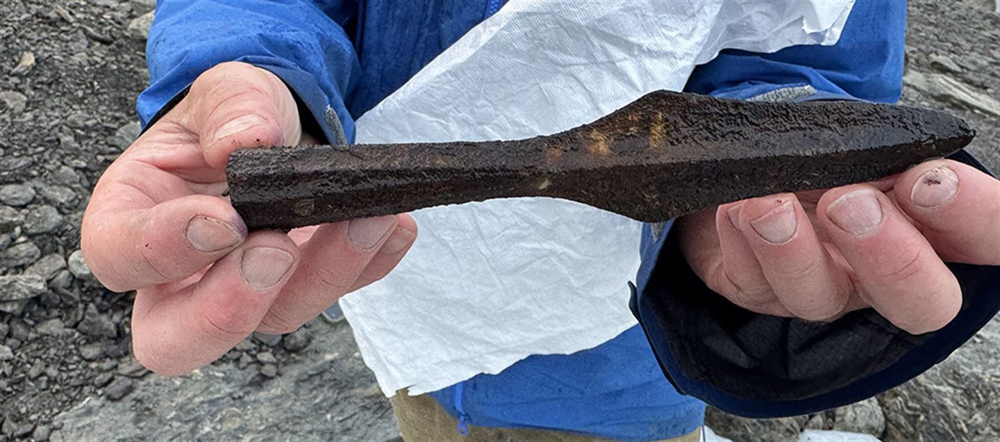 a man holding an iron spearhead