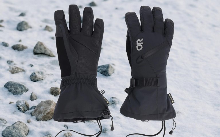 Outdoor Research gloves on sale at REI on a snowy rocky background