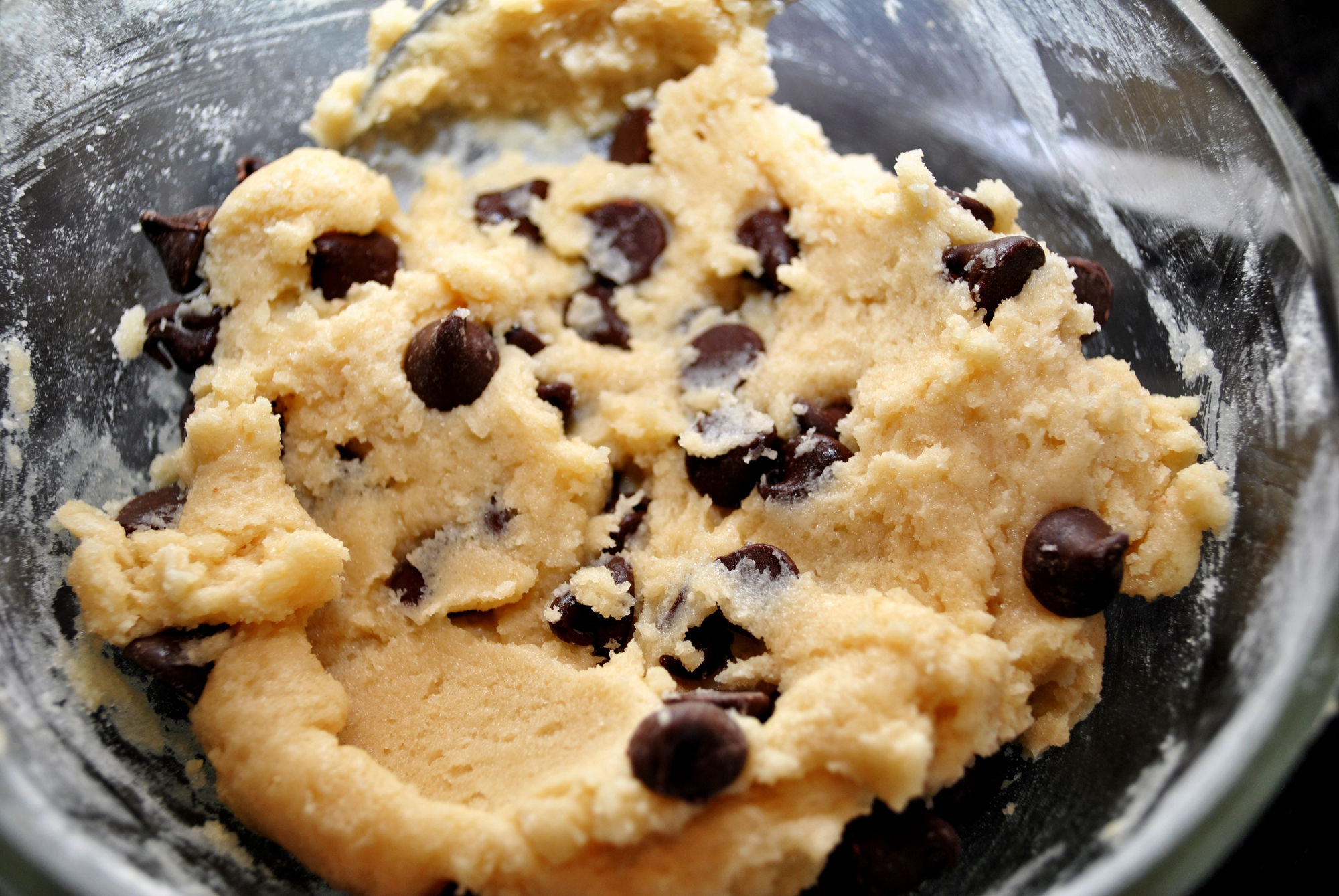 Chocolate chip cookie dough in a glass bowl, close up.