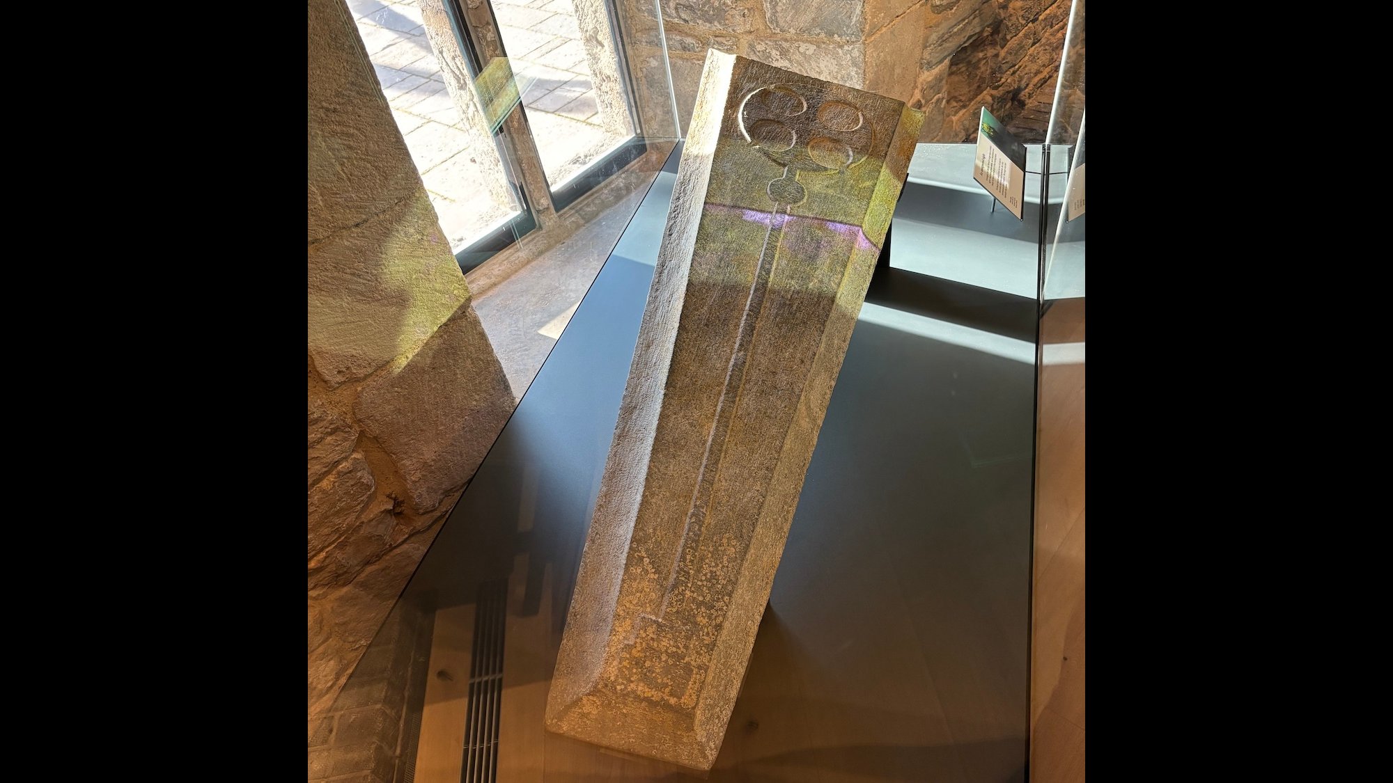 Medieval grave slab made from Purbeck stone in museum exhibit case