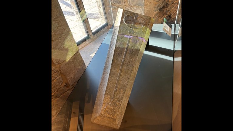 Medieval grave slab made from Purbeck stone in museum exhibit case