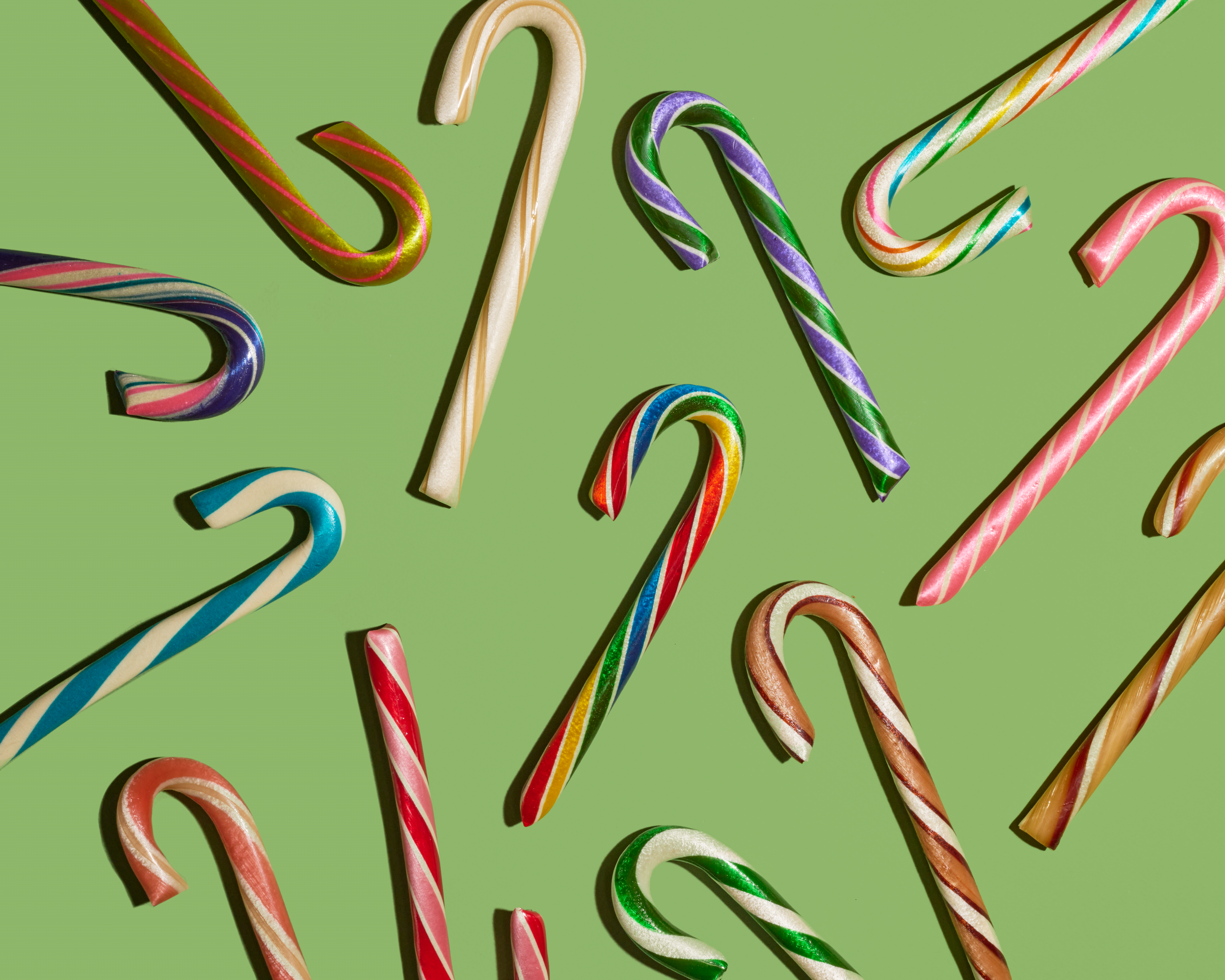 several multi-colored candy canes on a green background