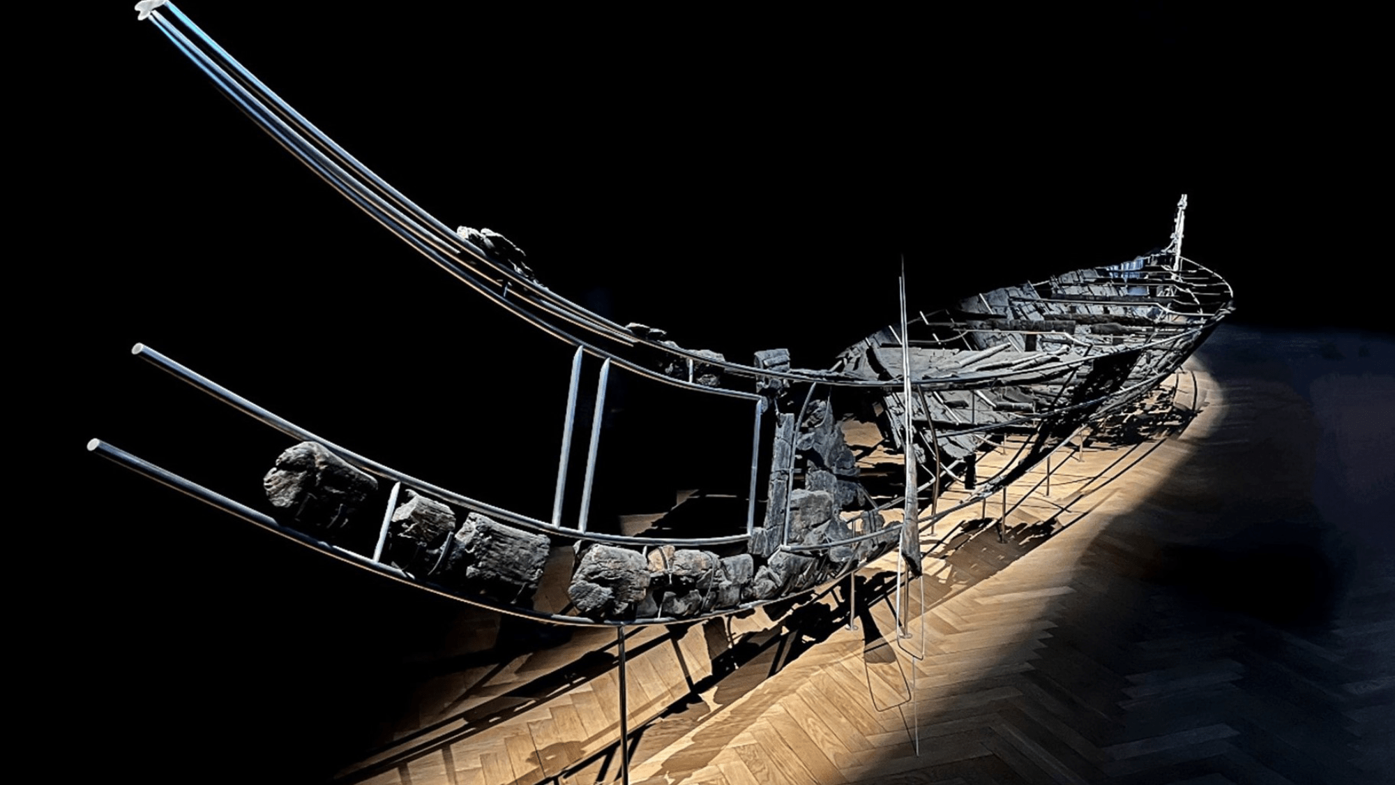 a wooden boat on display in a dark museum exhibit