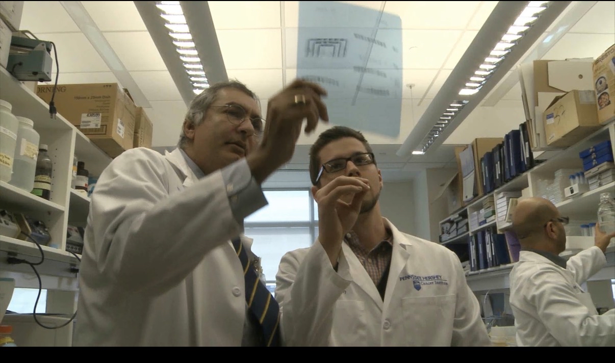 two men in lab coats working in a lab