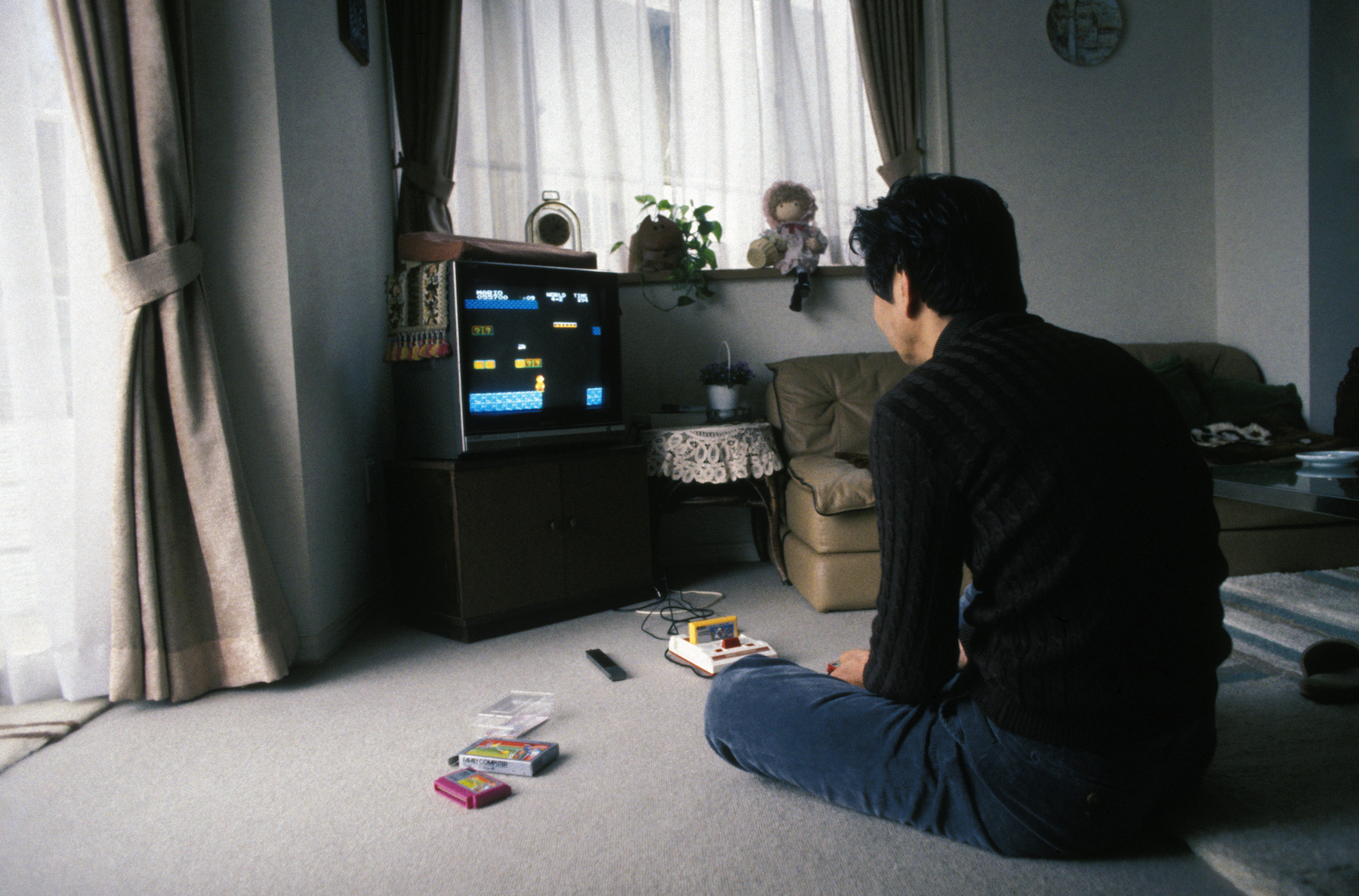 man sits on floor playing video game
