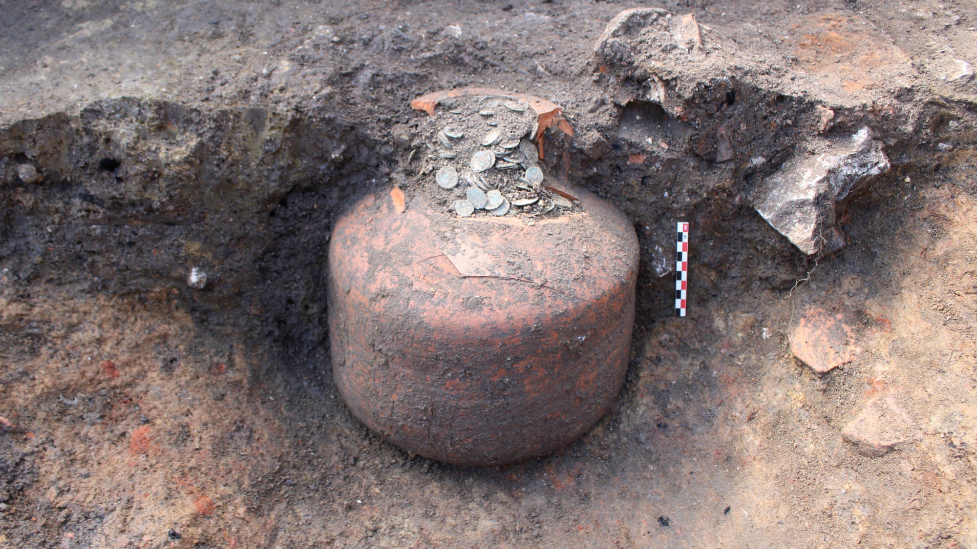 coins in a jug at an archaeologist dig