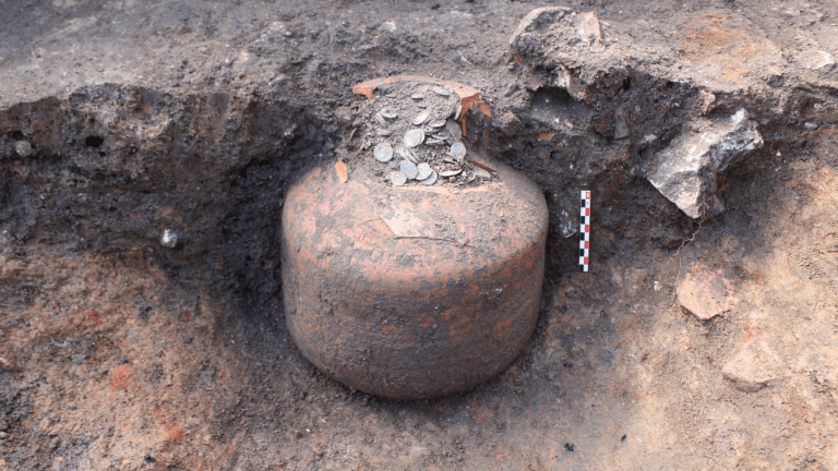 coins in a jug at an archaeologist dig