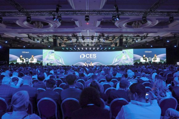 A crowded presentation at CS 2025, with keynote speakers shown on stage