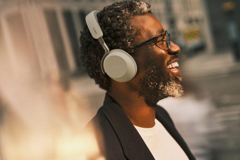 A smiling man wearing a Warm Grey Jabra Evolve3 75 headset out in public