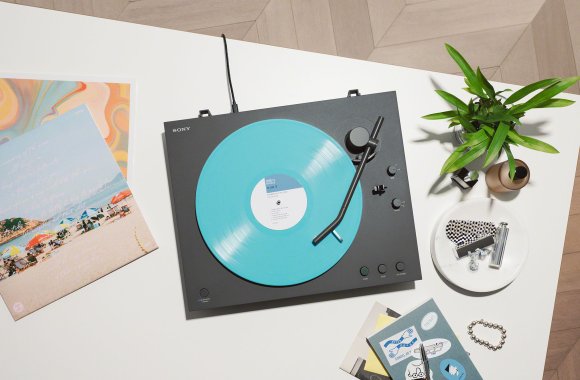 A Sony PS-LX3BT turntable playing turquoise colored vinyl.